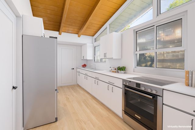 a kitchen with stainless steel appliances white cabinets and wooden floors