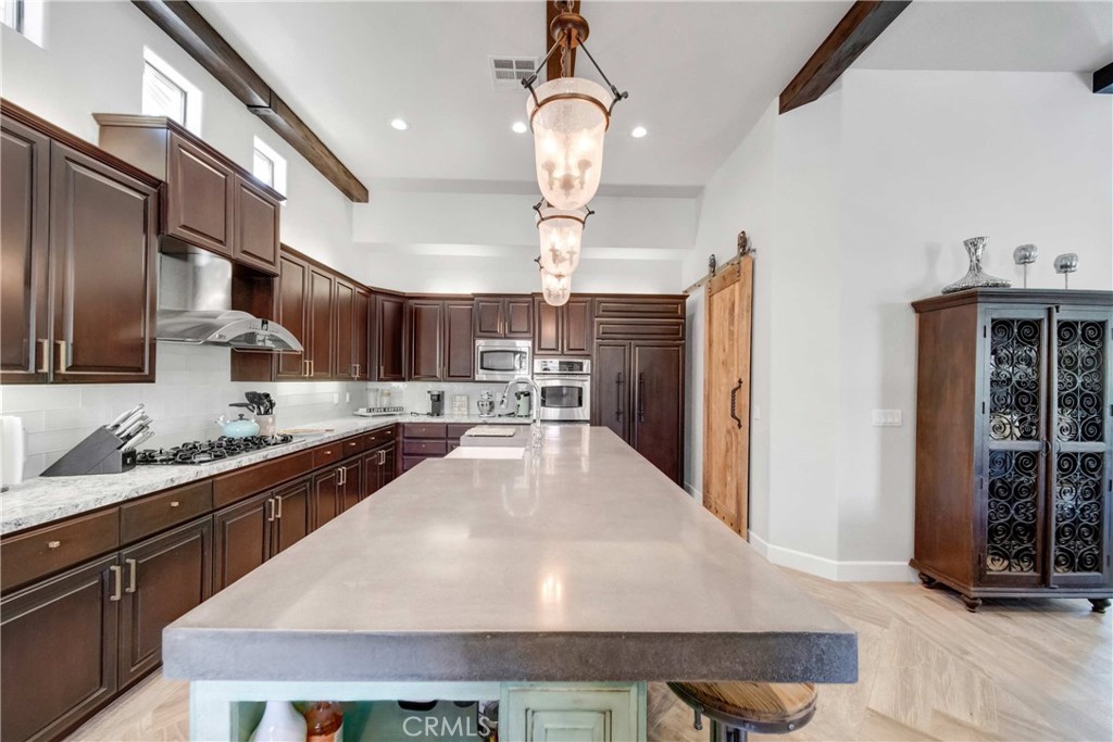 57721 Santa Rosa Trail La Quinta, CA 92253 - Photo 11 of 68 a large kitchen with granite countertop a stove oven and a sink with granite countertops