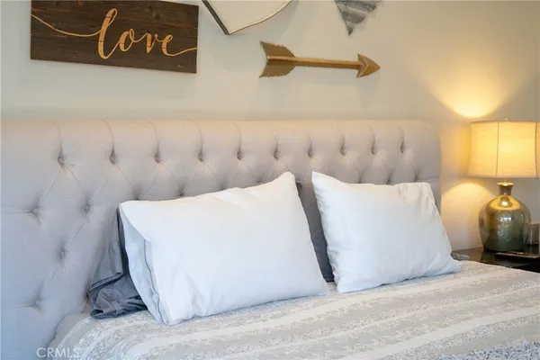 a bedroom with a bed dresser and a fireplace
