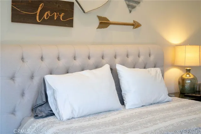 a bedroom with a bed dresser and a fireplace