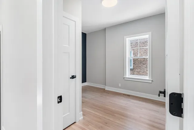 an empty room with wooden floor and a window