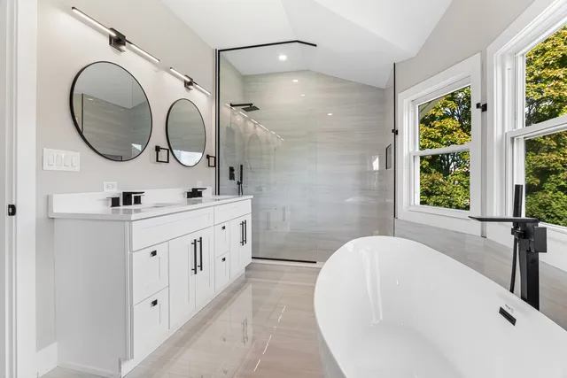 a white bath tub sitting in a bathroom next to a window