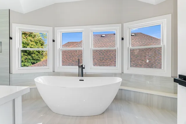 a bathroom with a bathtub sink and mirror