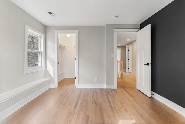 an empty room with wooden floor and a window