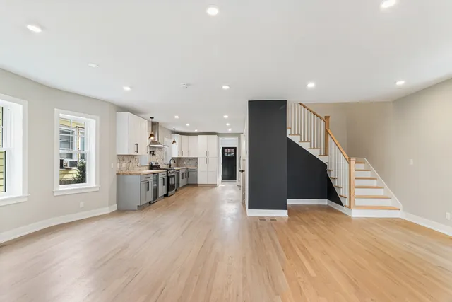 a view of a kitchen with wooden floor and windows