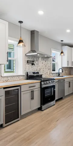 a kitchen with stainless steel appliances granite countertop a stove and cabinets