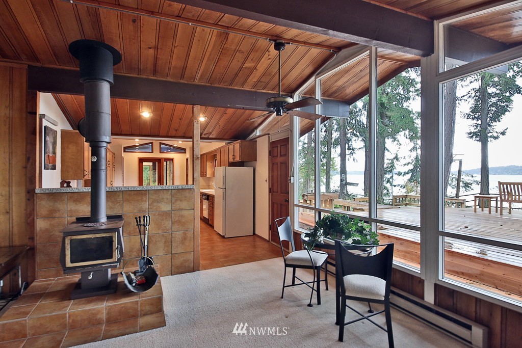 4576 South June Beach Road Freeland, WA 98249 - Photo 10 of 25 a dining room with furniture a fireplace and wooden floor