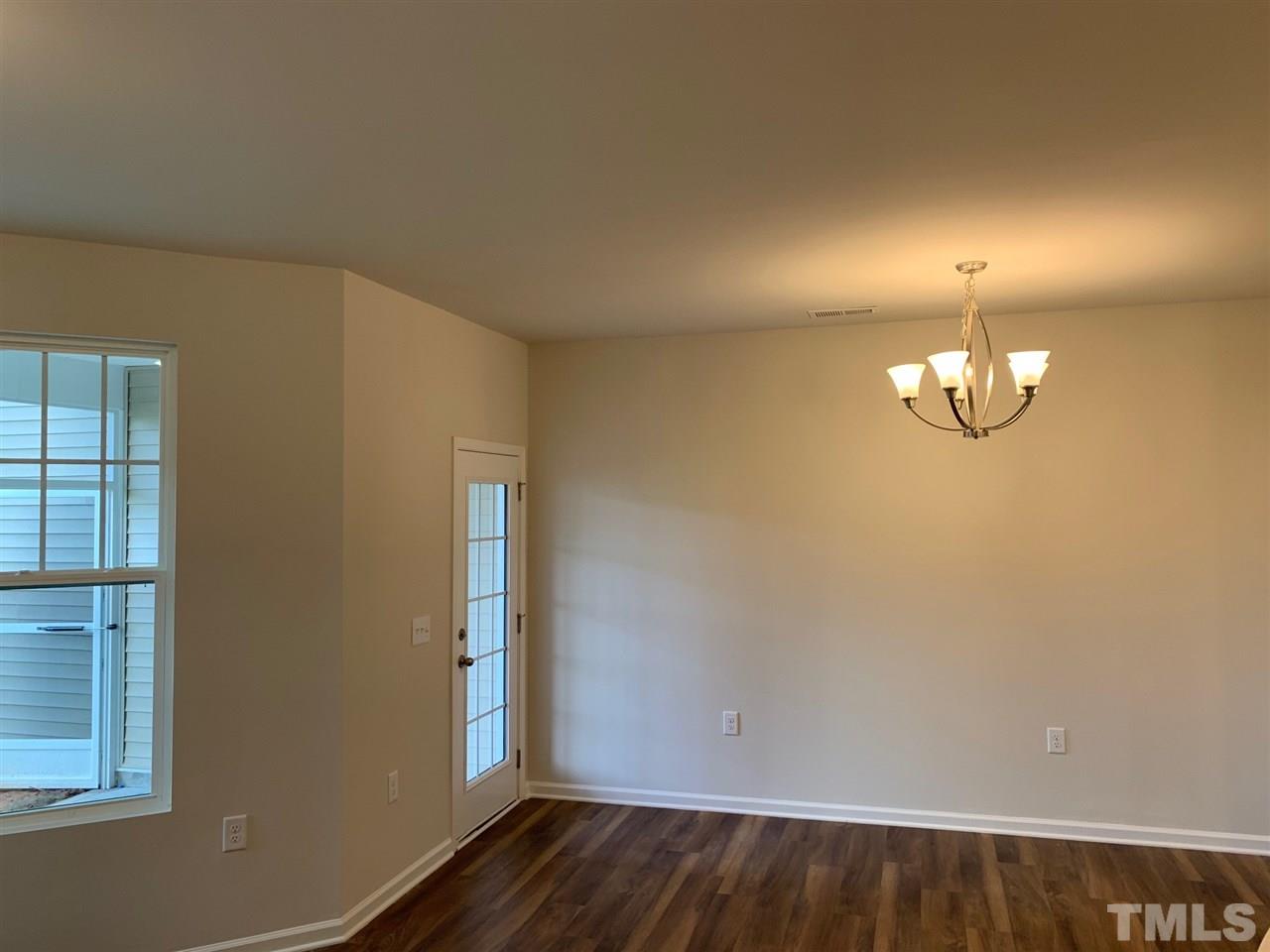 6102 Beale Loop, Unit 104 Raleigh, NC 27616 - Photo 11 of 29 an empty room with wooden floor and windows
