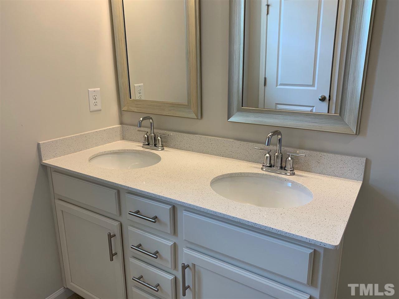 6102 Beale Loop, Unit 104 Raleigh, NC 27616 - Photo 13 of 29 a bathroom with double vanity sink and two mirror