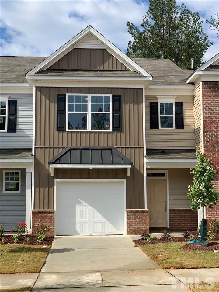 6102 Beale Loop, Unit 104 Raleigh, NC 27616 - Photo 25 of 29 a front view of a house with a yard and garage