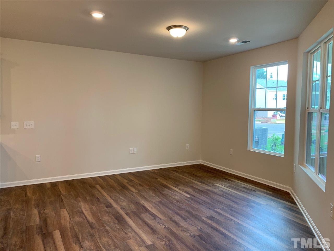 6102 Beale Loop, Unit 104 Raleigh, NC 27616 - Photo 10 of 29 an empty room with wooden floor and windows