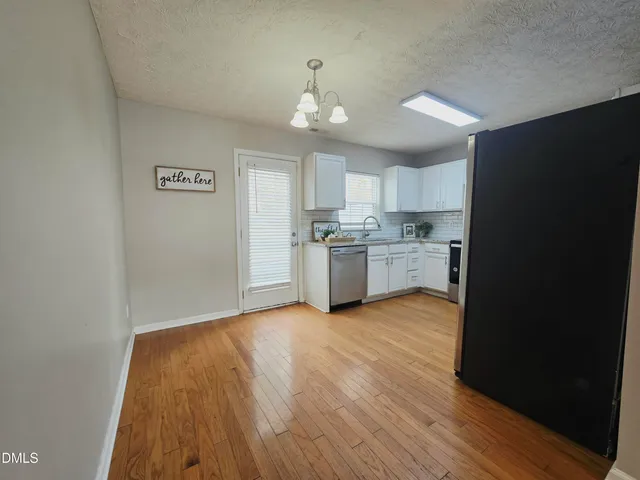a view of a kitchen with a stove wooden cabinets and a refrigerator