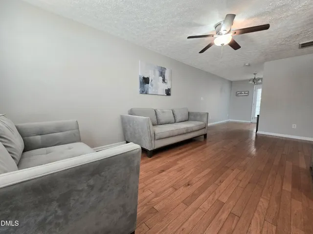 a living room with furniture and a chandelier