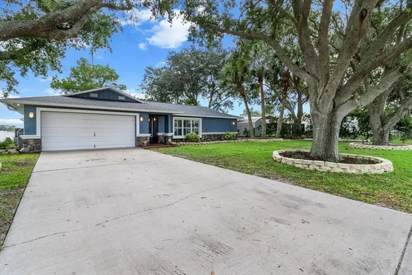 a front view of a house with a yard and trees