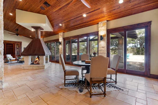 a dining room with furniture a chandelier and outdoor view