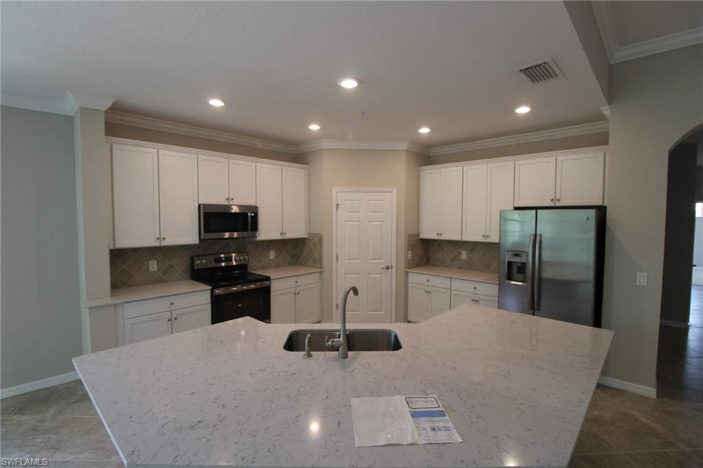 10539 Casella Way, Unit 202 Fort Myers, FL 33913 - Photo 17 of 28 a kitchen with stainless steel appliances granite countertop a refrigerator and a stove top oven