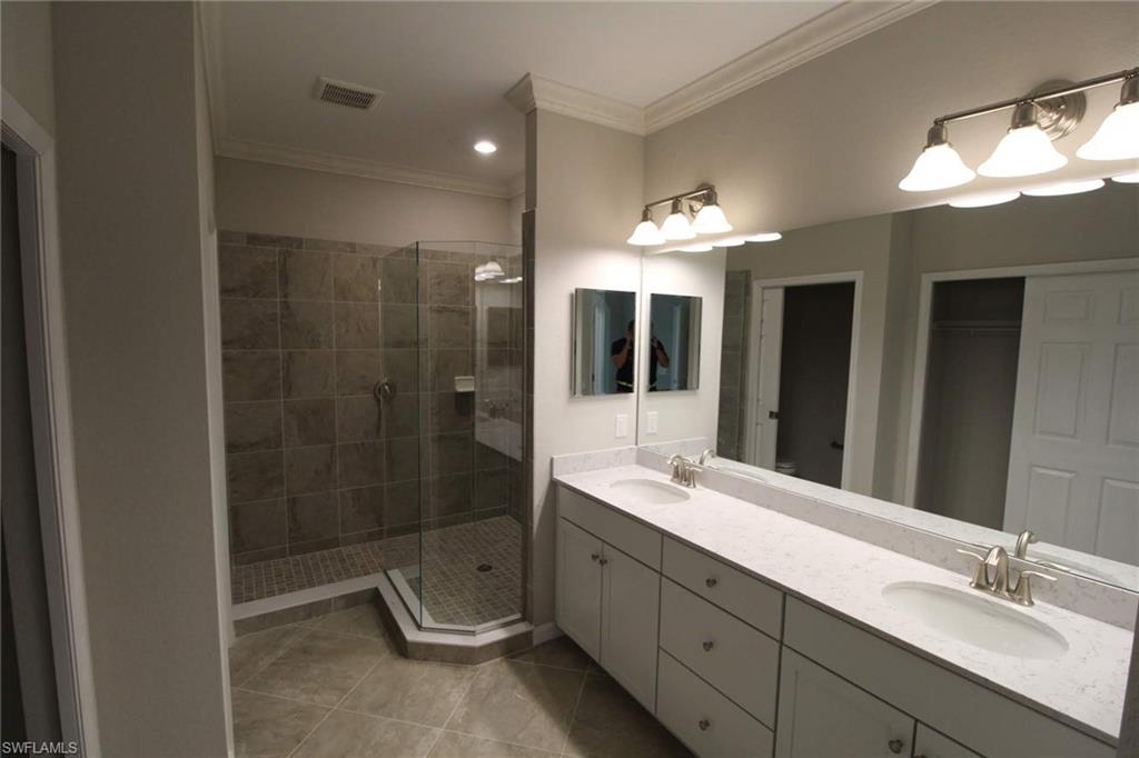 10539 Casella Way, Unit 202 Fort Myers, FL 33913 - Photo 21 of 28 a bathroom with a double vanity sink mirror and shower