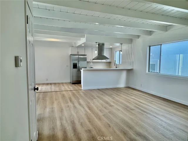 a view of a kitchen with wooden floor and electronic appliances