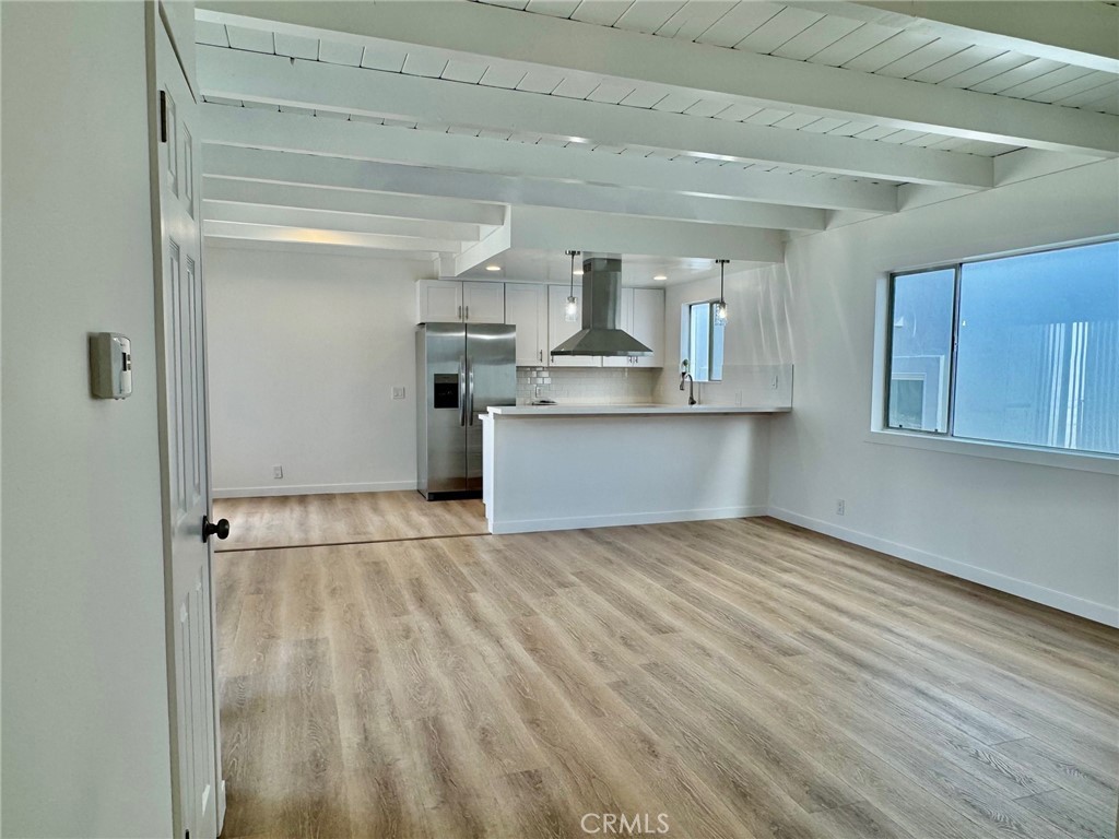a view of a kitchen with wooden floor and electronic appliances
