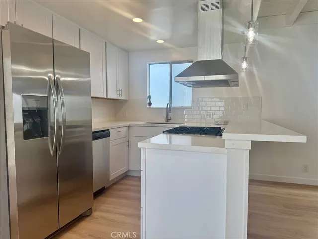a kitchen with stainless steel appliances a refrigerator and a stove