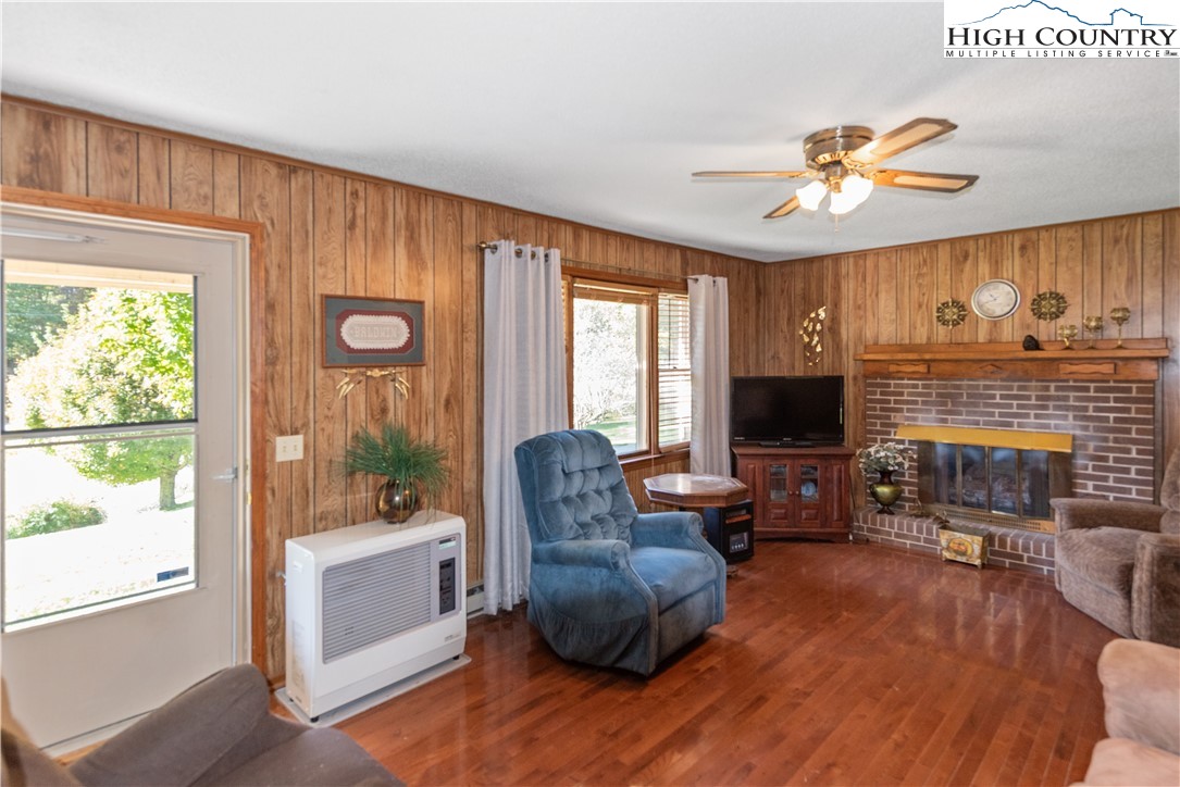 4934 Silas Creek Road Lansing, NC 28643 - Photo 14 of 32 a living room with furniture a fireplace and a flat screen tv