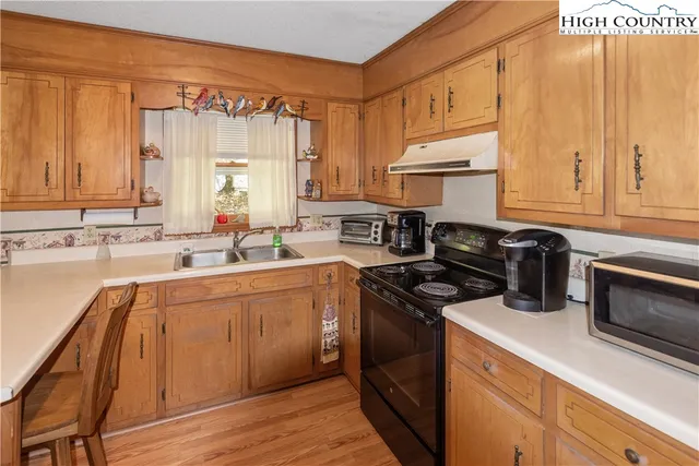 a kitchen with a sink stove top oven and cabinets