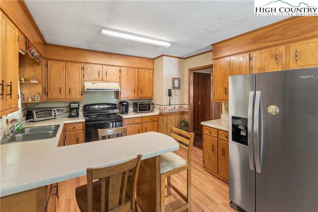 4934 Silas Creek Road Lansing, NC 28643 - Photo 19 of 32 a kitchen with stainless steel appliances a refrigerator sink and cabinets