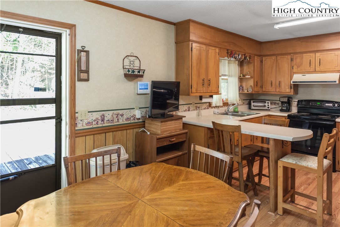 4934 Silas Creek Road Lansing, NC 28643 - Photo 20 of 32 a kitchen with a table chairs stove and cabinets