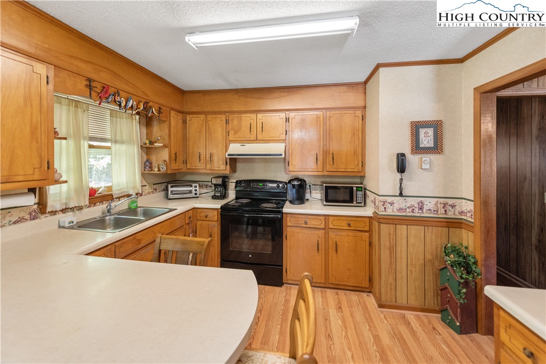 4934 Silas Creek Road Lansing, NC 28643 - Photo 21 of 32 a kitchen with granite countertop a stove a sink and a refrigerator
