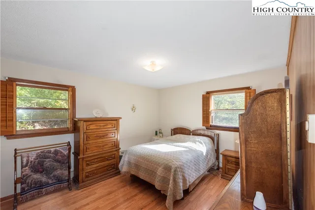 a bedroom with a bed and a dresser next to a window