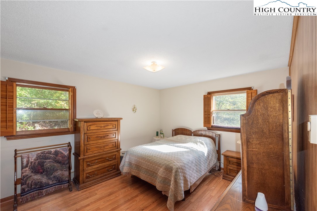 4934 Silas Creek Road Lansing, NC 28643 - Photo 22 of 32 a bedroom with a bed and a dresser next to a window