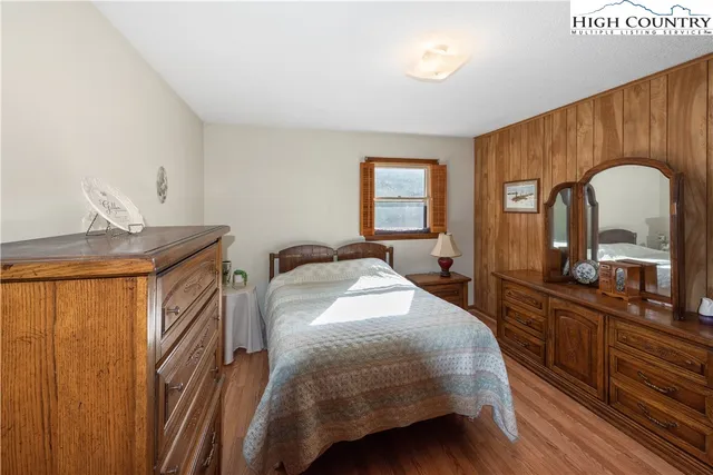 a bedroom with a bed a dresser and mirror