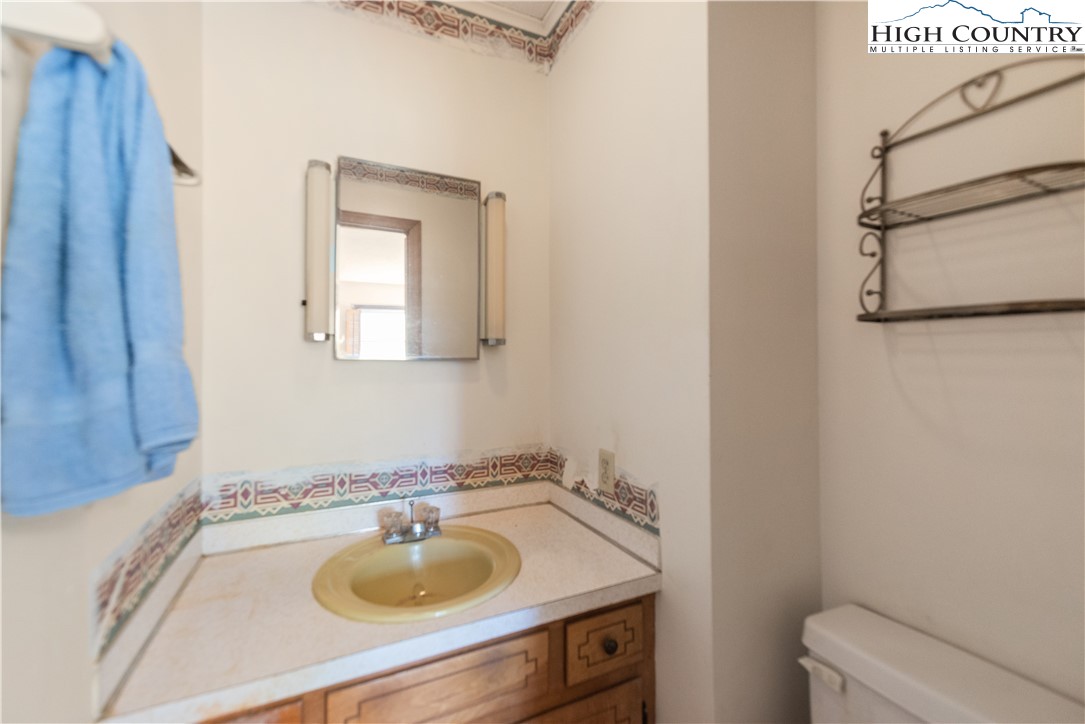 4934 Silas Creek Road Lansing, NC 28643 - Photo 24 of 32 a bathroom with a sink toilet and a mirror
