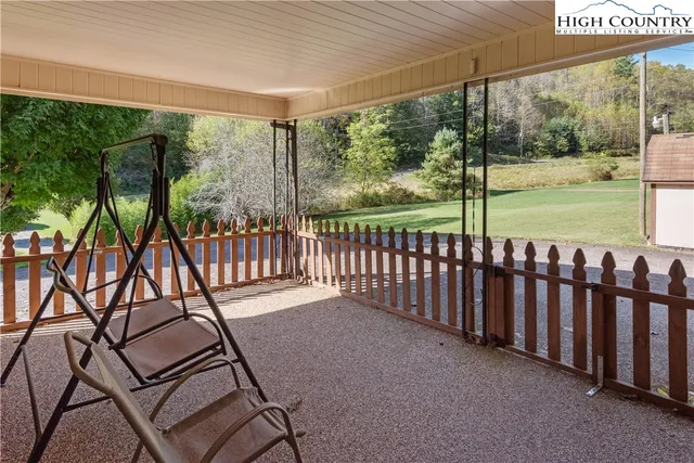 a view of a porch with wooden floor and fence