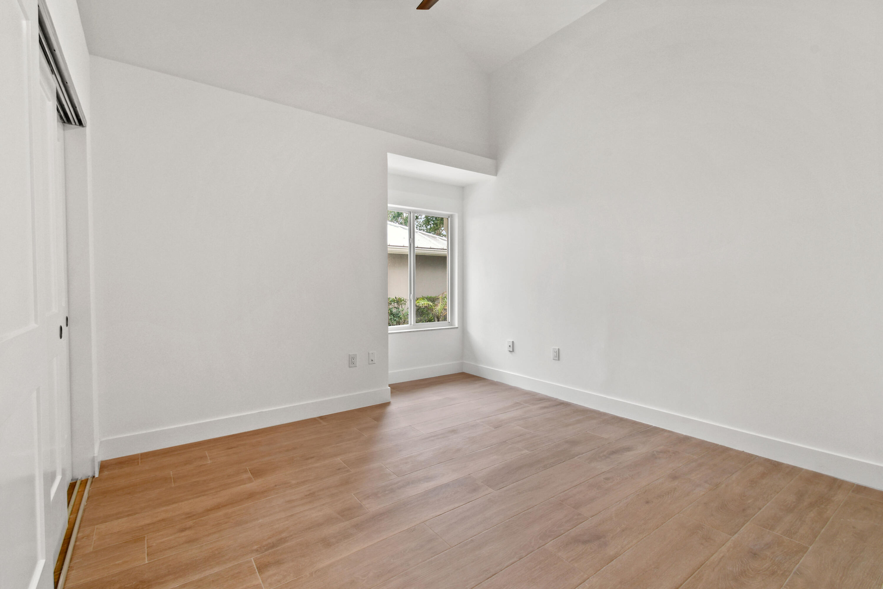 114 Inner Harbour Way Jupiter, FL 33477 - Photo 22 of 38 a view of an empty room with wooden floor and a window