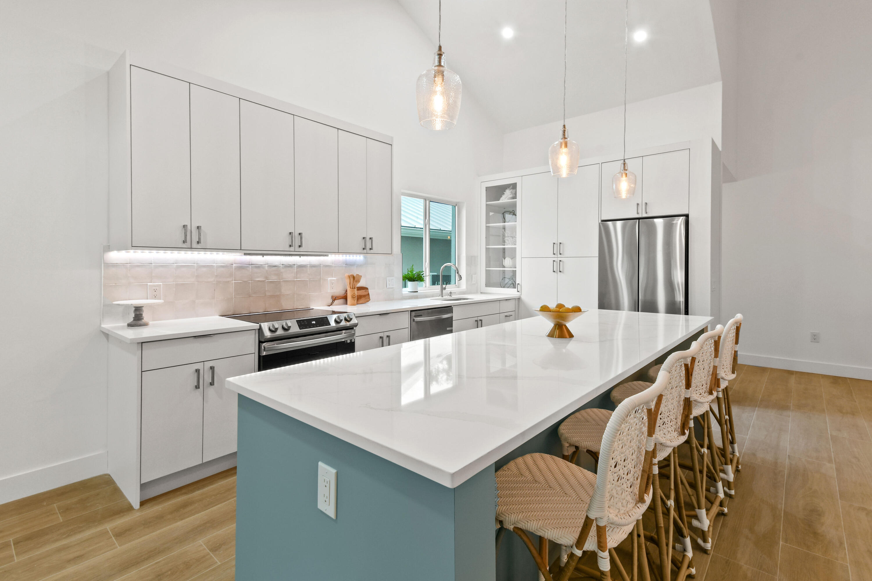 114 Inner Harbour Way Jupiter, FL 33477 - Photo 4 of 38 a kitchen with a sink a stove a refrigerator and white cabinets with wooden floor