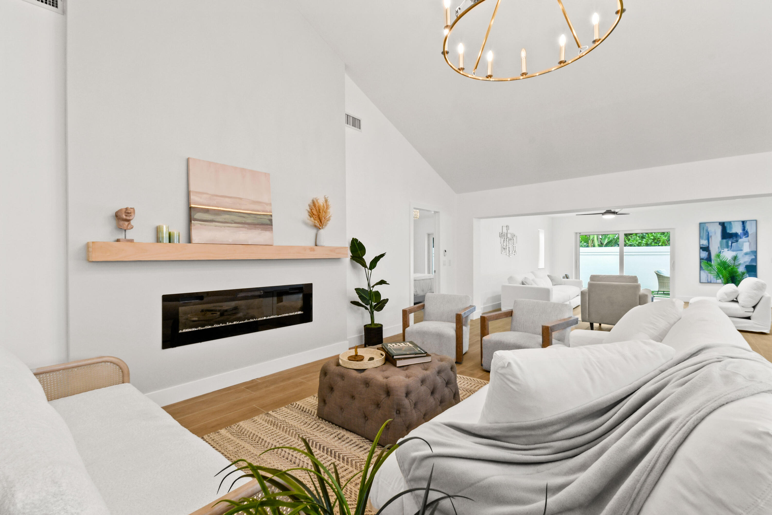 114 Inner Harbour Way Jupiter, FL 33477 - Photo 8 of 38 a living room with furniture a fireplace and a chandelier