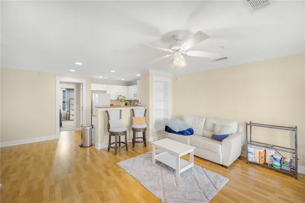 a living room with furniture and a dining table with wooden floor