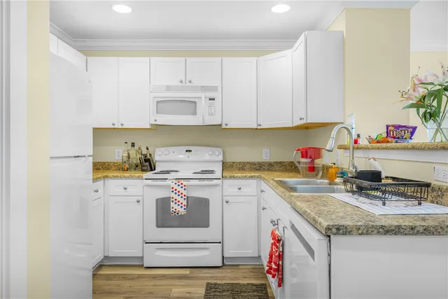 a kitchen with a sink a stove and white cabinets