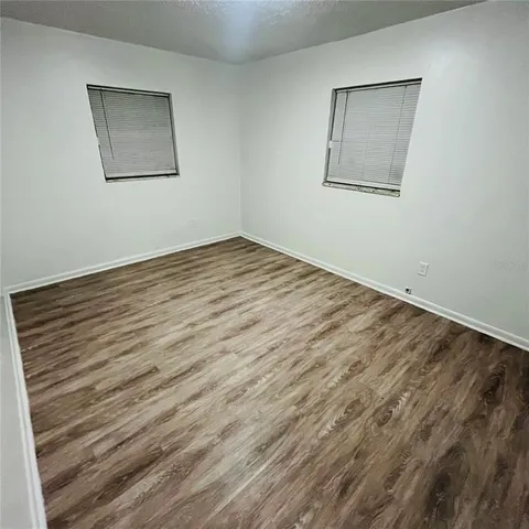 a view of empty room with wooden floor