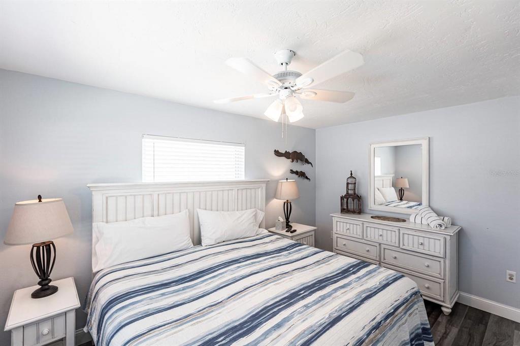6020 Midnight Pass Road, Unit 52A Sarasota, FL 34242 - Photo 15 of 28 a bedroom with a bed and a chandelier