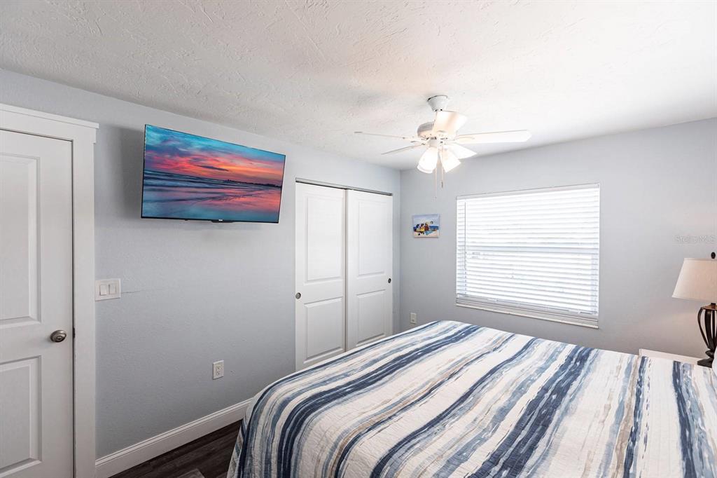 6020 Midnight Pass Road, Unit 52A Sarasota, FL 34242 - Photo 16 of 28 a bedroom with a bed and a chandelier