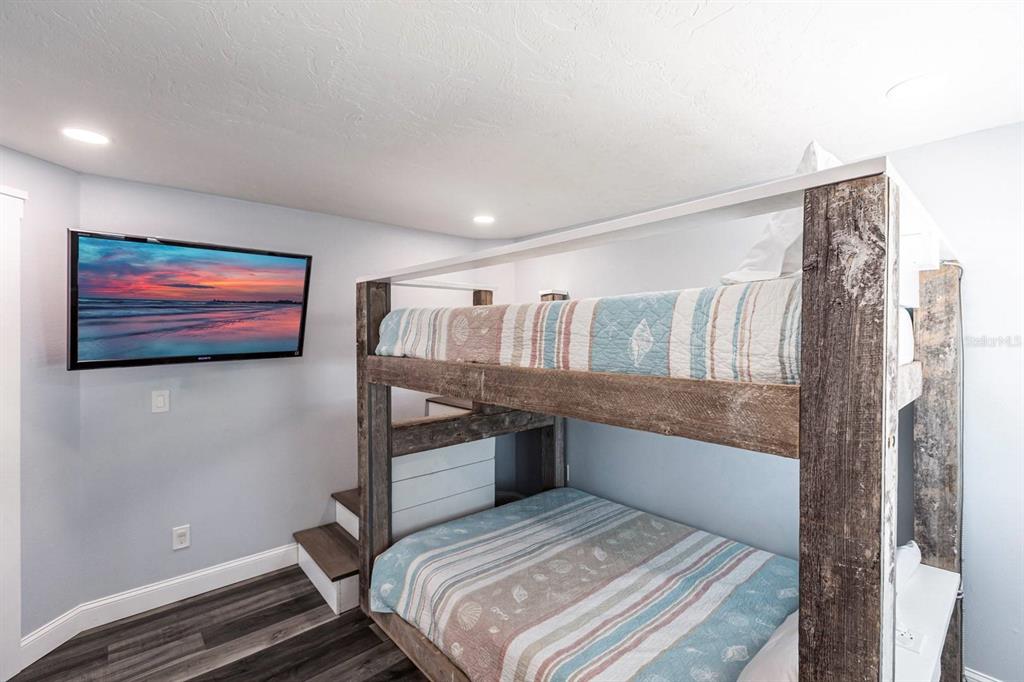 6020 Midnight Pass Road, Unit 52A Sarasota, FL 34242 - Photo 17 of 28 a bedroom with a bed and a flat screen tv