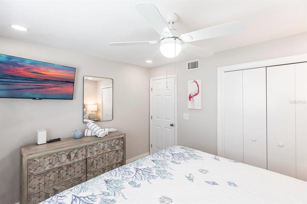 6020 Midnight Pass Road, Unit 52A Sarasota, FL 34242 - Photo 19 of 28 a spacious bedroom with a bed and a chandelier