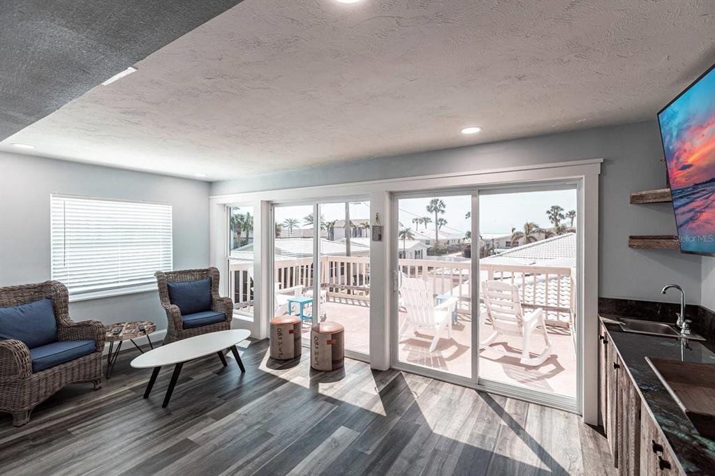 6020 Midnight Pass Road, Unit 52A Sarasota, FL 34242 - Photo 2 of 28 a living room with furniture and a flat screen tv