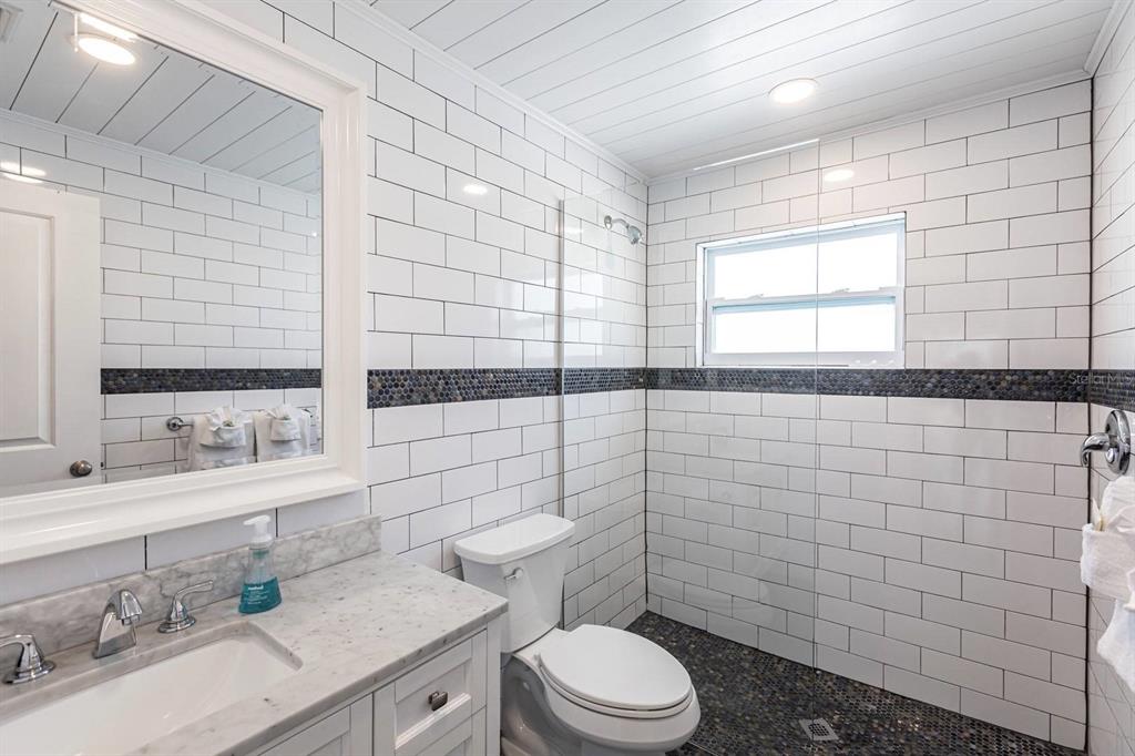 6020 Midnight Pass Road, Unit 52A Sarasota, FL 34242 - Photo 22 of 28 a bathroom with a sink a toilet and shower