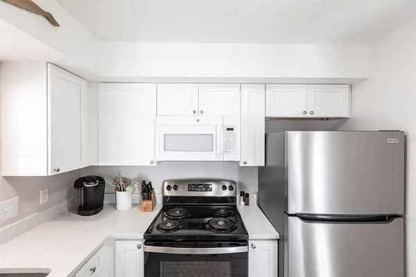 a kitchen with a refrigerator and a stove top oven