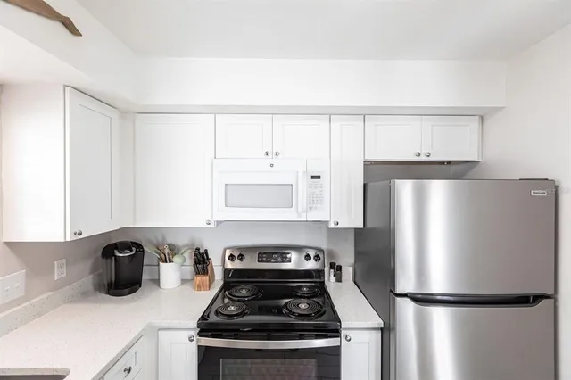 a kitchen with a refrigerator and a stove top oven