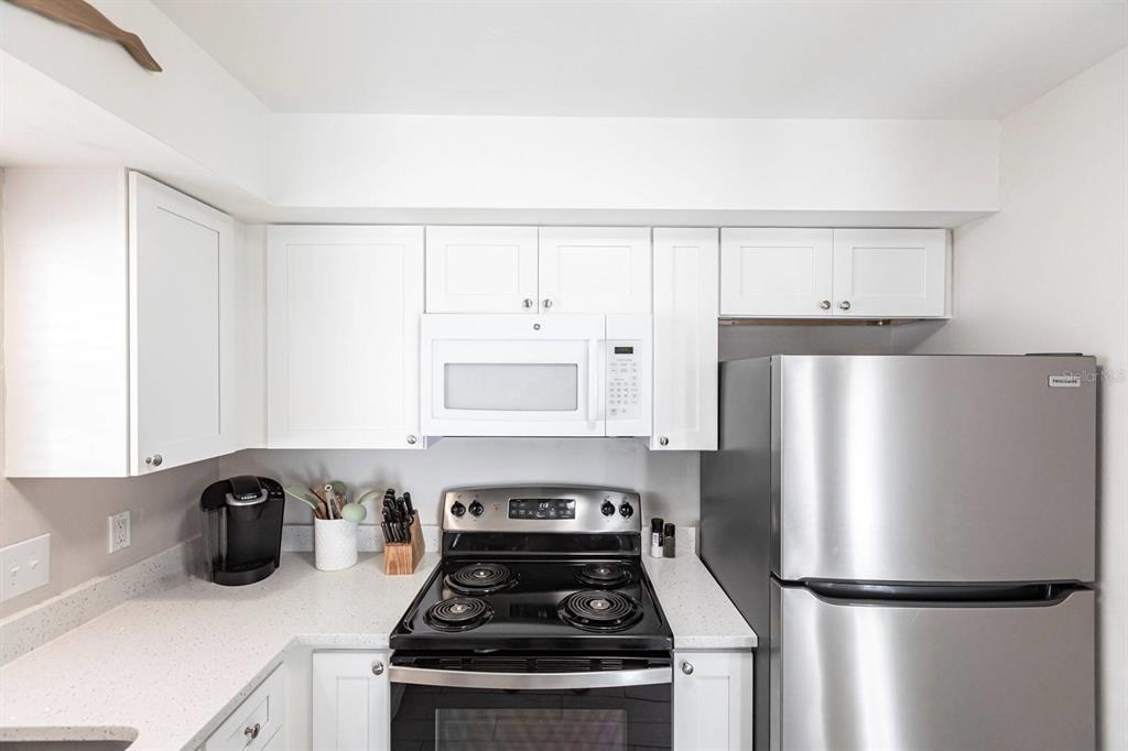 6020 Midnight Pass Road, Unit 52A Sarasota, FL 34242 - Photo 7 of 28 a kitchen with a refrigerator and a stove top oven