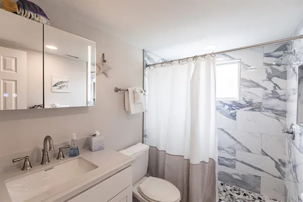 a bathroom with a sink toilet and shower